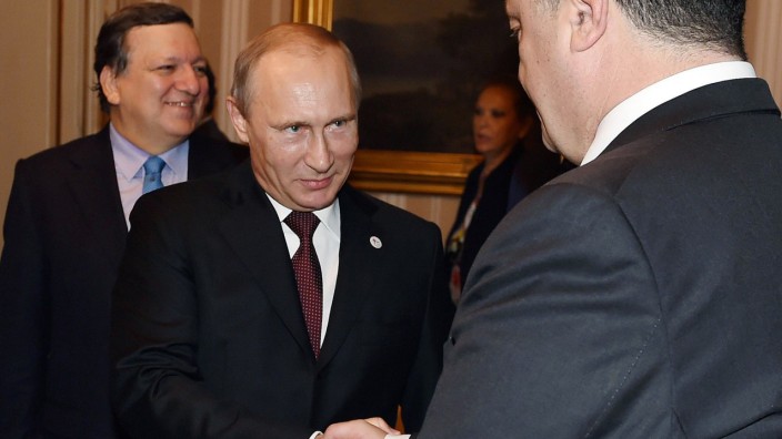 Krisentreffen in Mailand zur Ukraine: Das Lächeln wirkt angestrengt: Russlands Präsident Putin schüttelt dem ukrainischen Staatschef Poroschenko die Hände. Das Gespräch mit Poroschenko beschreibt Putin als positiv.