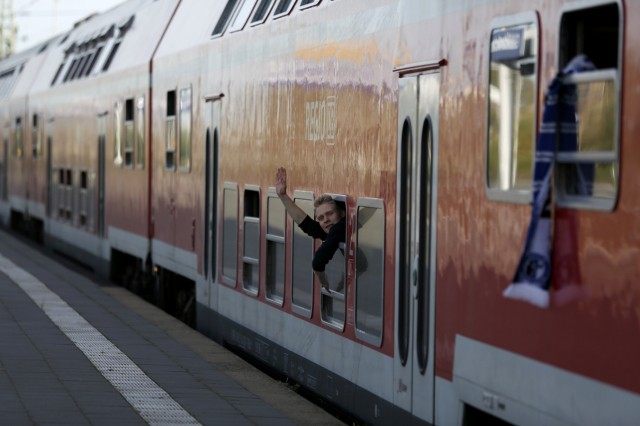 Man waves from Deutsche Bahn special train carrying Hertha Berlin football fans for Bundesliga soccer match in Gelsenkirchen