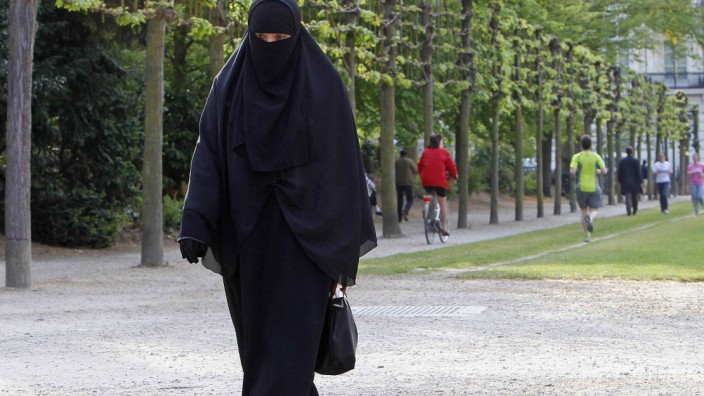 Salma, French national living in Belgium who chooses to wear niqab after converting to Islam, walks in park in Brussels