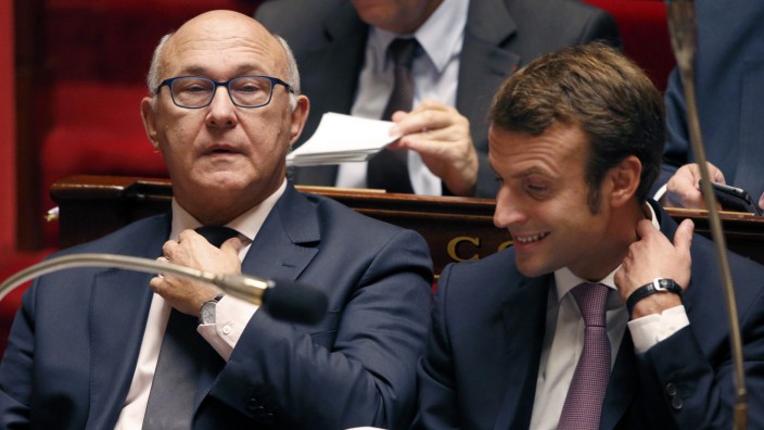 French Finance Minister Michel Sapin and Economy Minister Emmanuel Macron attend the questions to the government session at the National Assembly in Paris