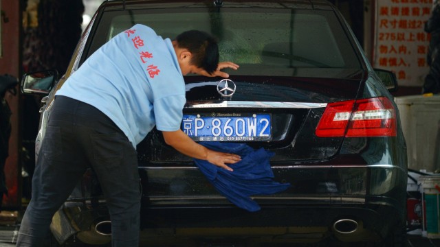 Chinesischer Arbeiter wäscht einen Mercedes in Beijing