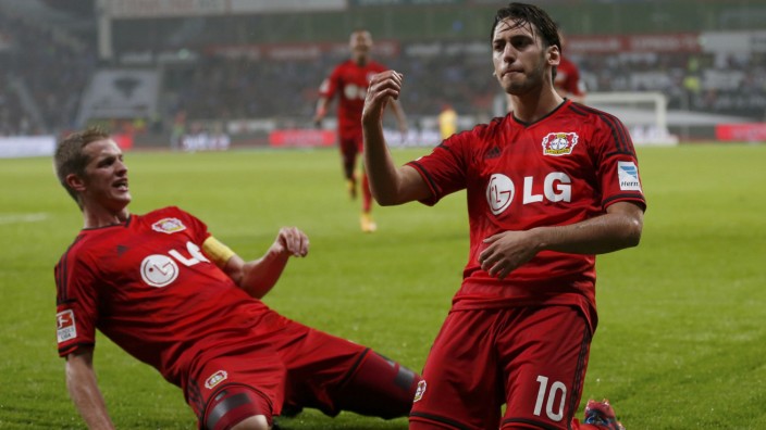 Bayer Leverkusen's Calhanoglu celebrates with Bender after scoring against Schalke 04 during Bundesliga soccer match in Leverkusen