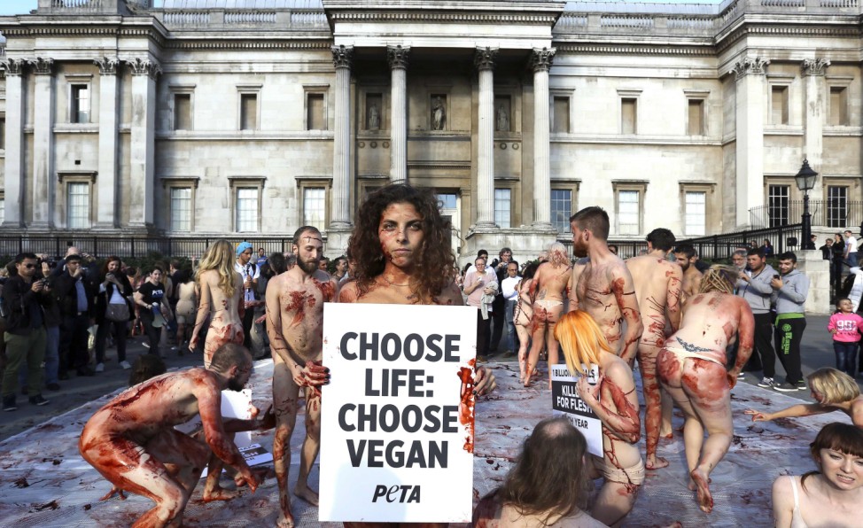 Naked woman poses for photographs as around 100 PETA supporters gathered to lay nearly nude in a heap in Trafalgar Square to raise awareness on World Vegan Day in London