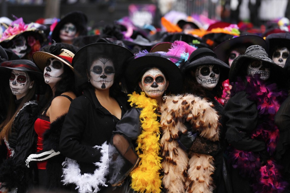 Women, with faces painted to look like the popular Mexican figure called 'Catrina', take part in a world record attempt in downtown Mexico City