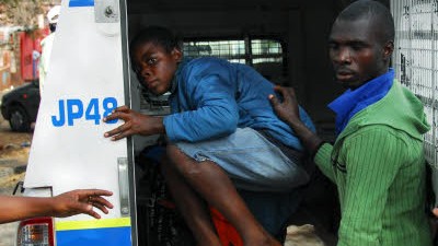 Fremdenfeindlichkeit in Südafrika: In Jeppestown in Johannesburg flüchtet sich ein junger Zuwanderer in ein Polizeiauto.