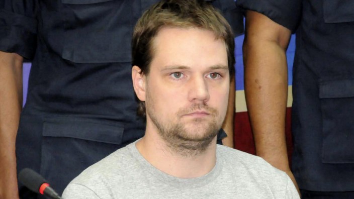 Pirate Bay co-founder Neij is surrounded by policemen at the immigration office in Nong Khai province