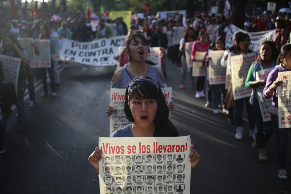 Women shout slogans and hold posters with pictures of the 43 missing students from the Ayotzinapa teachers' training college, during a demonstration to demand justice for the 43 missing students, in Mexico City