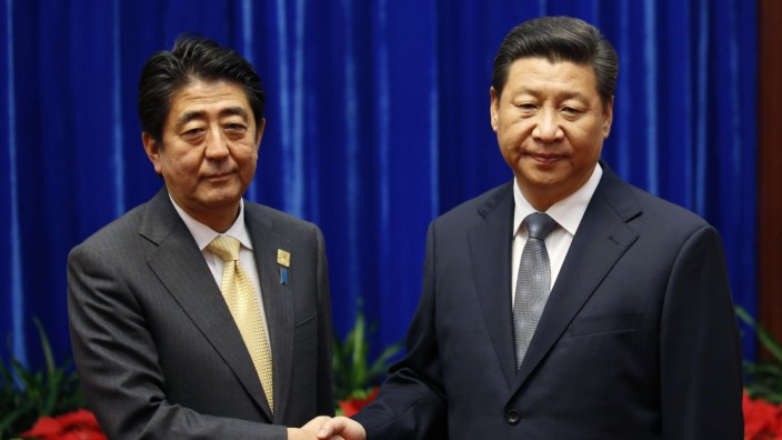 China's President Xi Jinping shakes hands with Japan's Prime Minister Shinzo Abe during their meeting on the sidelines of the APEC meetings in Beijing