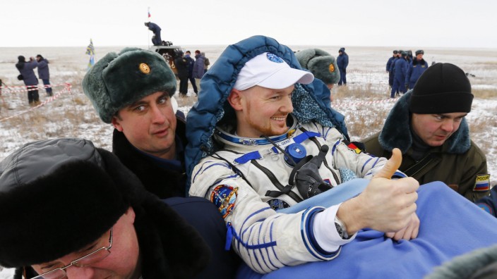 Ground personnel carry International Space Station crew member Gerst of Germany shortly after landing near the town of Arkalyk in northern Kazakhstan
