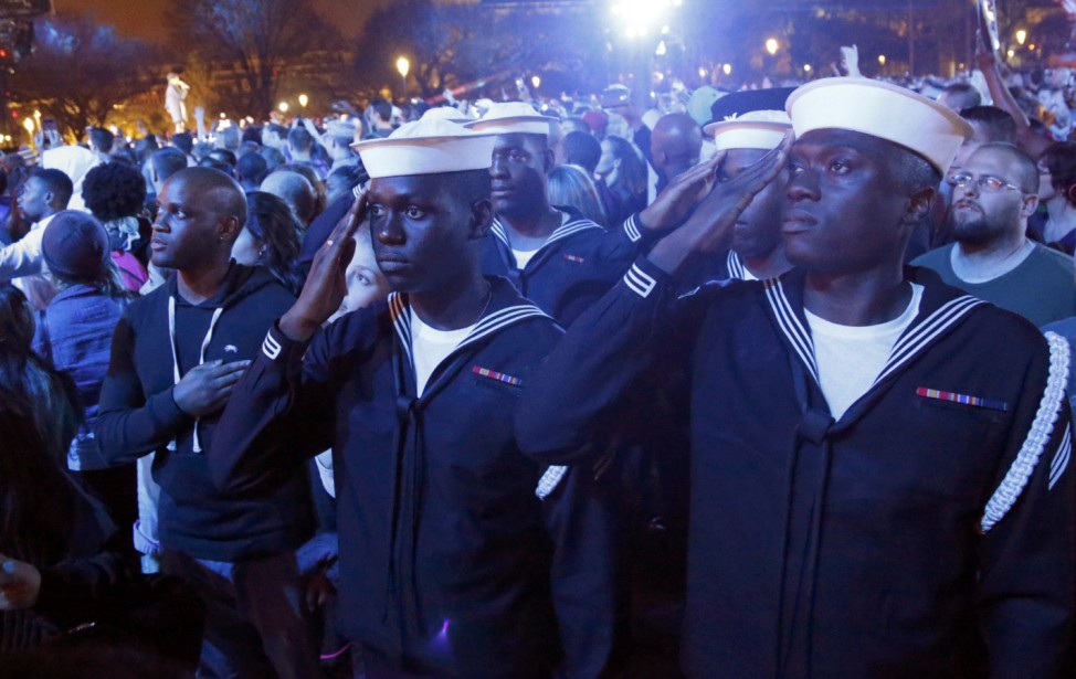 Sailors salute during the singing of the U.S. National Anthem at the Concert for Valor on the National Mall on Veterans' Day in Washington