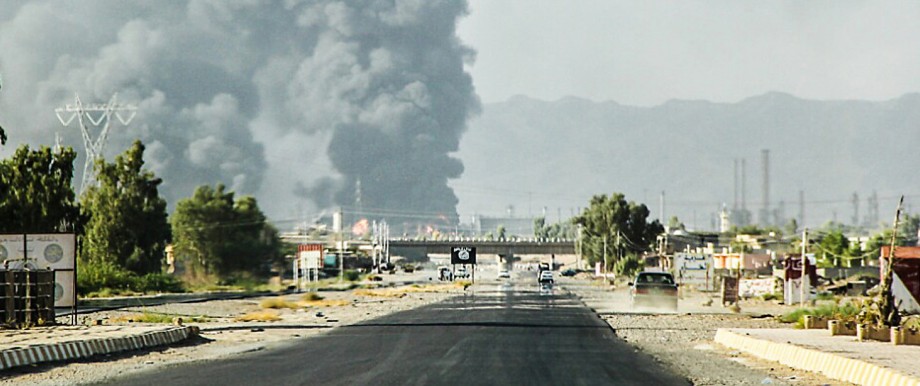 Geheime Dokumente über Islamischen Staat: Rauch steigt auf über einer Ölraffinerie nahe Bagdad. Der Islamische Staat (IS) versucht auch immer wieder Ölfelder in seine Gewalt zu bekommen. Die Haupteinnahmequelle der Terrororganisation liegt jedoch woanders.