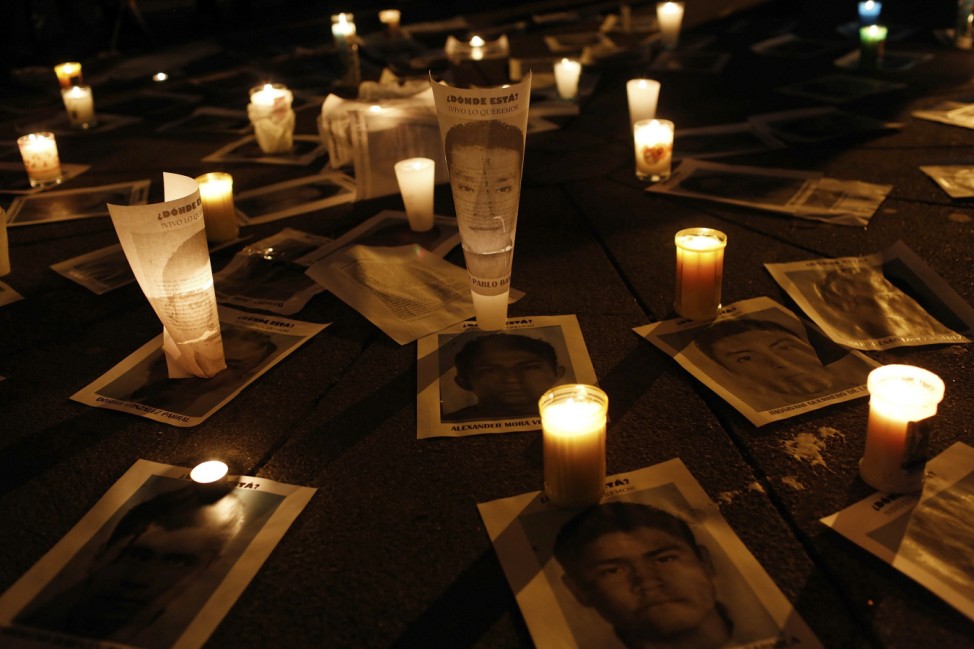 Candles are place over photographs of the missing 43 trainee teachers during a march in Mexico City