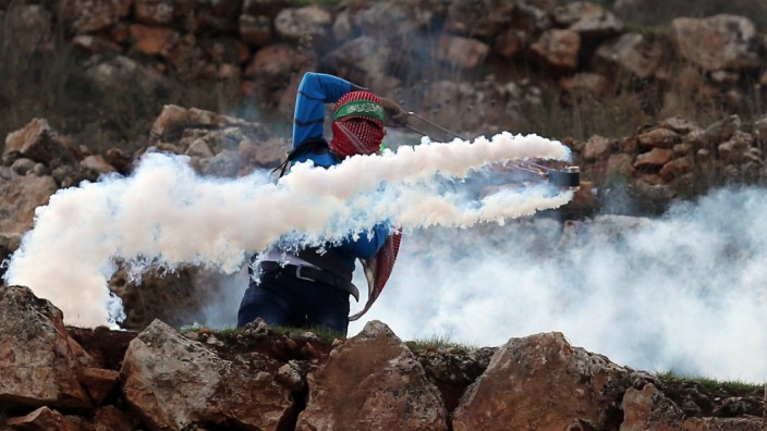 Nahostkonflikt: In der Nähe von Ramallah wehrt sich ein junger Palästinenser gegen das israelische Militär und schleudert Tränengas zurück.