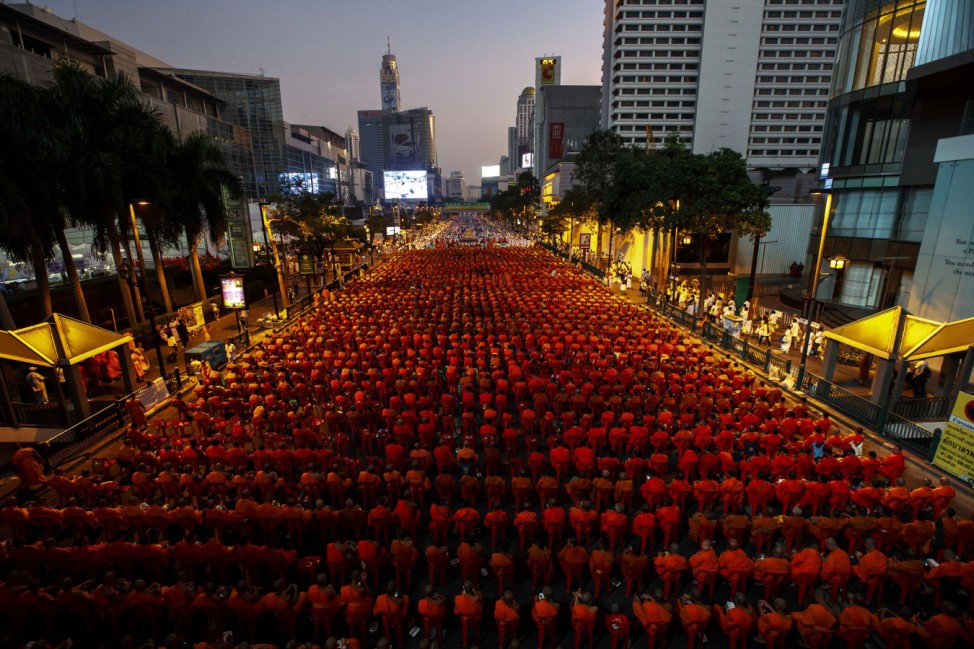 Thousands of Buddhist monks attend a mass alms-offering ceremony in Bangkok's shopping district