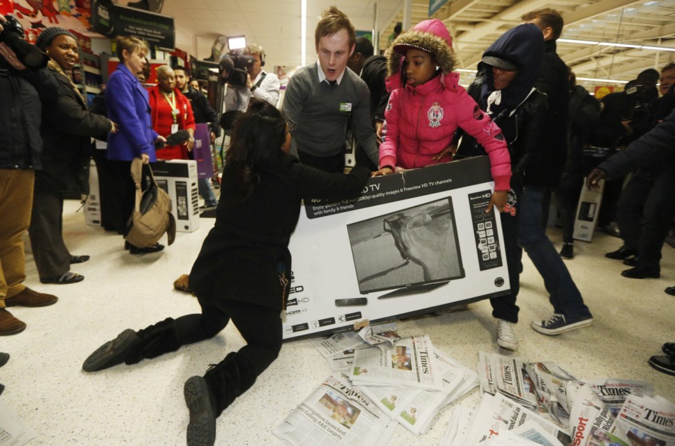 Shoppers wrestle over a television as they compete to purchase retail items on 'Black Friday' at an Asda superstore in Wembley