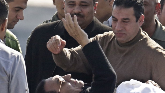 Prozess in Ägypten eingestellt: Ägyptens ehemaliger Staatschef Hosni Mubarak grüßt, auf einer Trage liegend, seine Unterstützer.