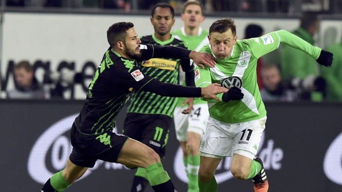 Wolfsburg's Olic is challenged by Moenchengladbach's Dominguez during their German first division Bundesliga soccer match in Wolfsburg