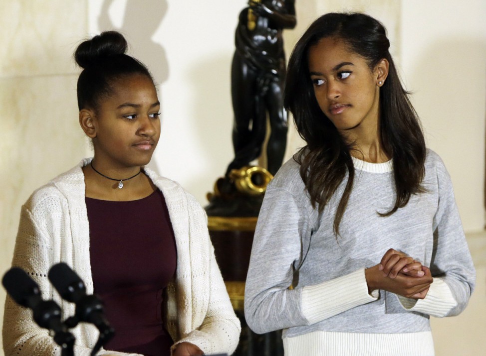 Sasha and Malia Obama listen to their father at the National Thanksgiving Turkey pardoning at White House in Washington