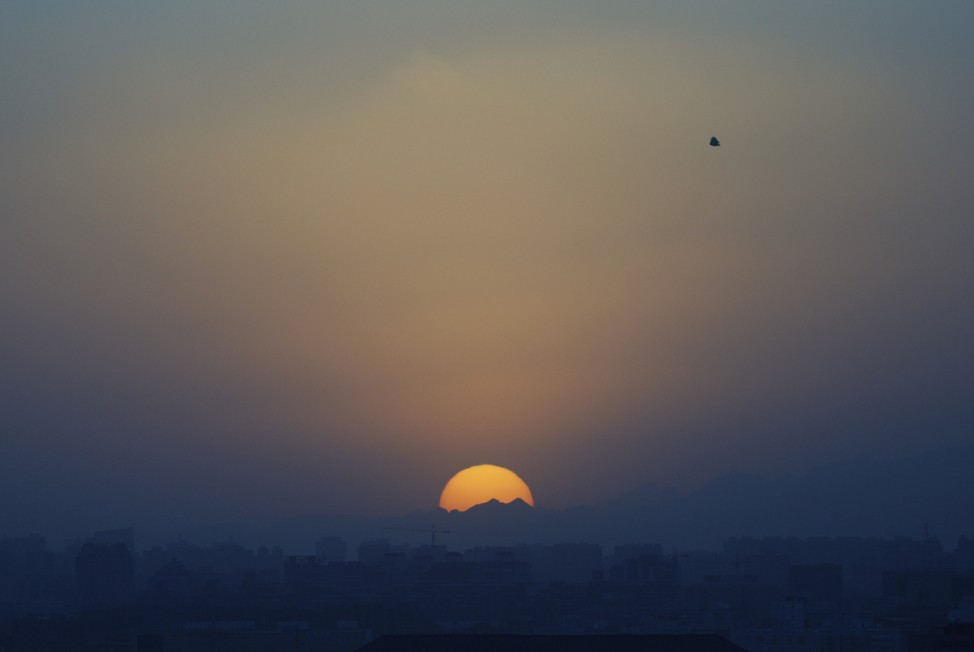 A plastic bag flies over residential buildings as the sunsets in Beijing, China