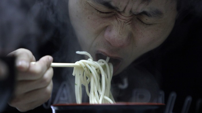 A man eats noodle at a restaurant in Shanghai
