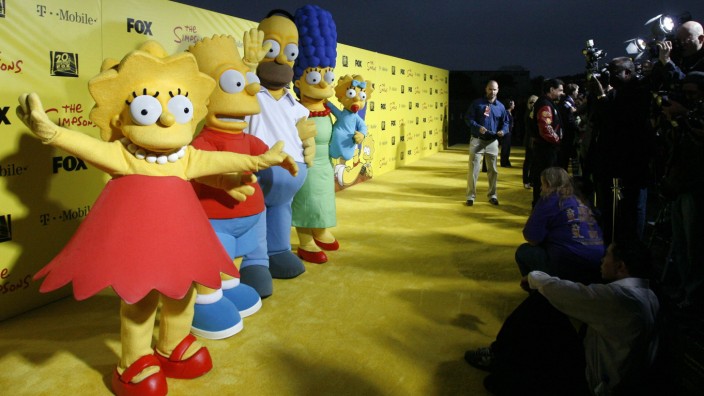 Characters Lisa, Bart, Homer, Marge and Maggie stand by a cake at the 20th anniversary party for the television series 'The Simpsons' in Santa Monica