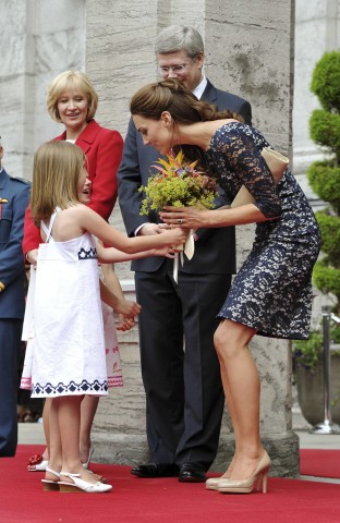 Britain's Catherine, Duchess of Cambridge is presented with flowers by two local girls, as she stands with Canada's Prime Minister Stephen Harper and his wife Laureen, after arriving at Rideau Hall in Ottawa