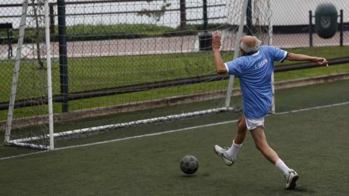 A senior soccer player runs to score a goal during a match at a soccer field in Miraflores