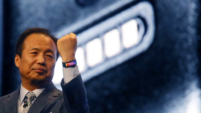File photo of Shin, president and Head of IT and Mobile Communication Division of Samsung Electronics, showing off company's new Gear Fit fitness band during its launching ceremony at the Mobile World Congress in Barcelona