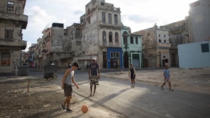 People play soccer on the street in downtown Havana