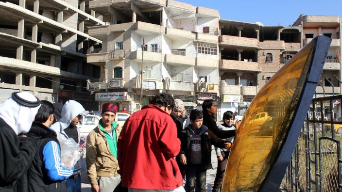 Syrien: In der syrischen Stadt Al-Rakka sehen sich Menschen die Reste des abgestürzten jordanischen Flugzeugs an.