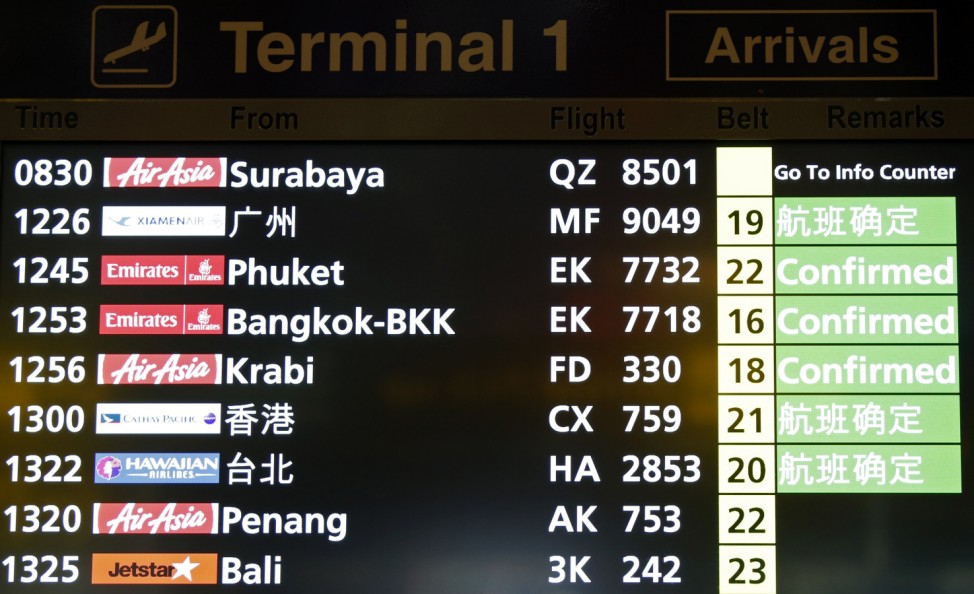 A flight information signboard shows the status of AirAsia flight from Indonesian city of Surabaya to Singapore at Changi Airport in Singapore