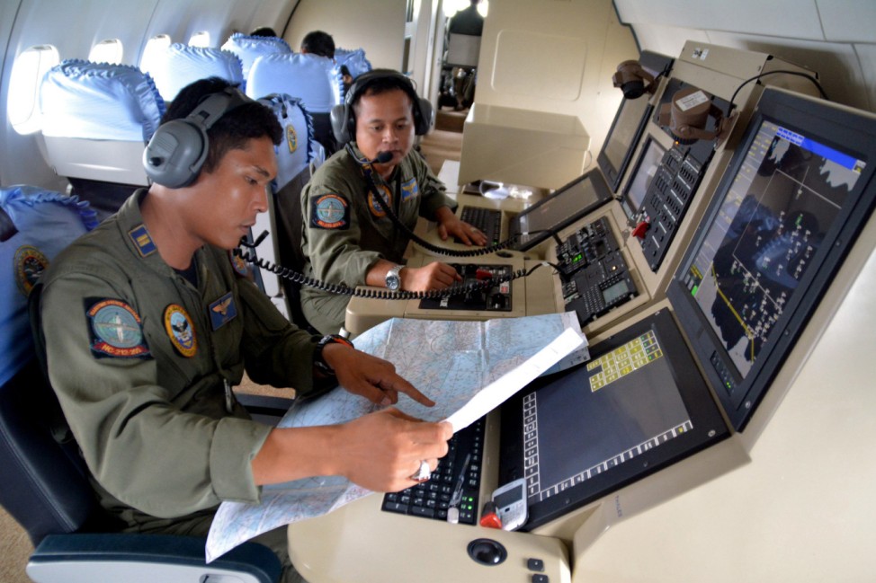 Members from the Indonesian Navy's Tactical Commanding Operator help with the search for AirAsia flight QZ 8501on board a CN235 aircraft over Karimun Java in the Java Sea
