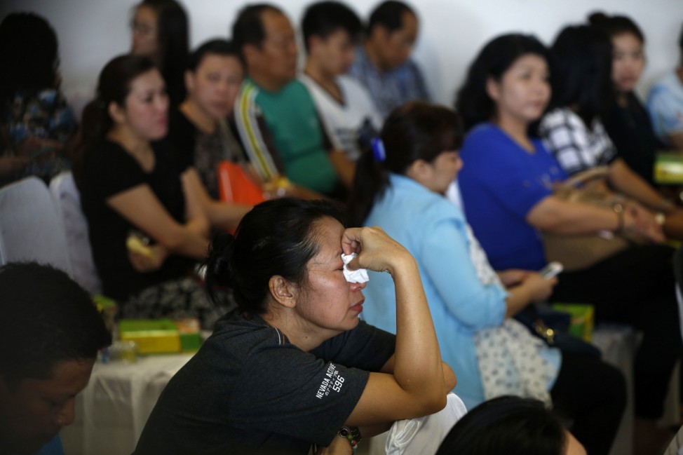 Family members of passengers onboard missing AirAsia flight QZ8501 react as they await news in Juanda International Airport, Surabaya