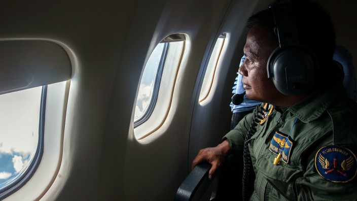 Vermisstes Air-Asia-Flugzeug: Ein indonesischer Soldat blickt aus dem Fenster eines Suchflugzeugs. Mehr als 120 000 Quadratkilometer werden nach der verschwundenen Maschine der Air Asia durchkämmt.