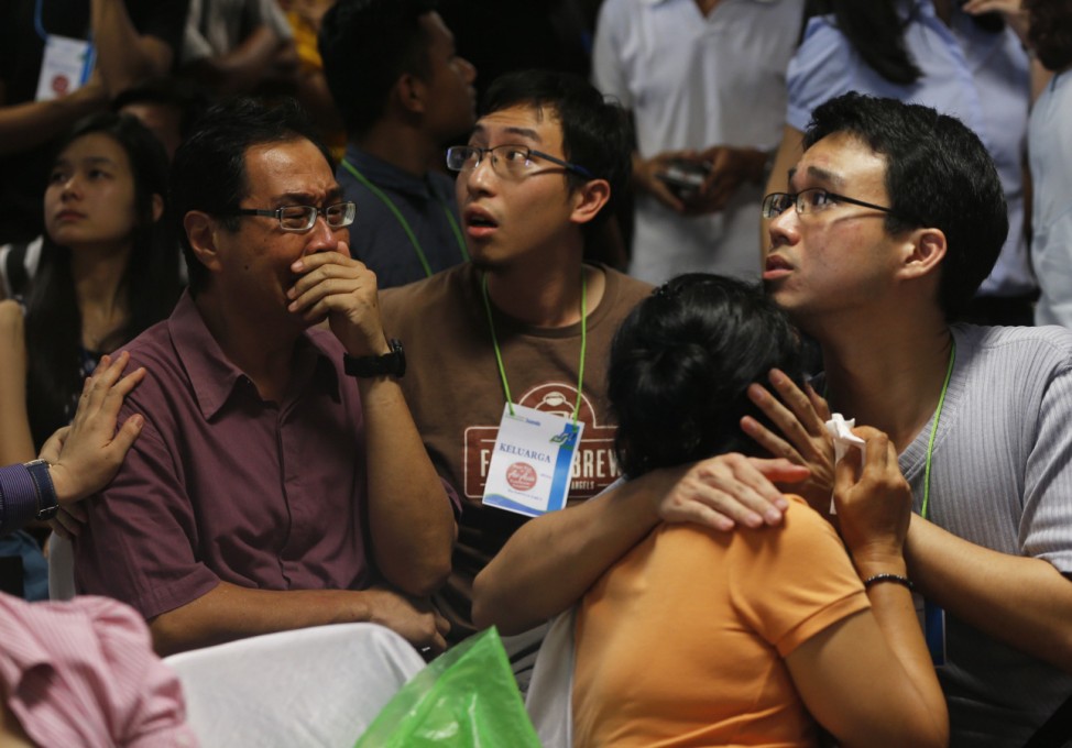 Family members of passengers onboard missing AirAsia flight QZ8501 cry at a waiting area in Juanda International Airport