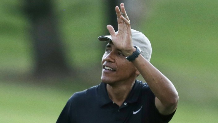 Obama waves to crowd at Mid-Pacific Country Club in Kailua during Hawaiian holiday vacation