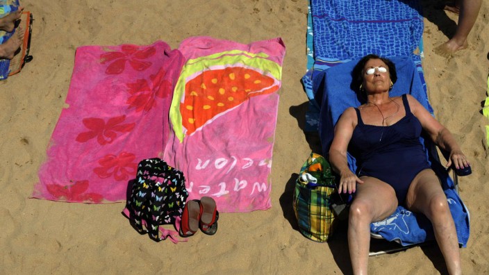 A woman sunbathes on San Lorenzo beach in Gijon