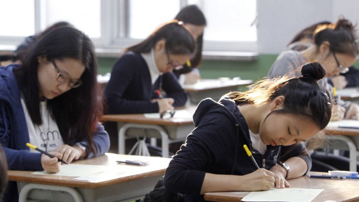 Südkorea: Südkoreanische Schülerinnen beim Aufmahmetest für das College: Am Tag des Tests gelten Flugverbote, der Feierabendverkehr wird reguliert, um die Schüler ja nicht zu stören.