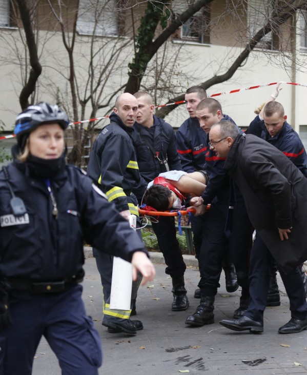 Firefighters carry a victim on a stretcher at the scene after a shooting at the Paris offices of Charlie Hebdo, a satirical newspaper,