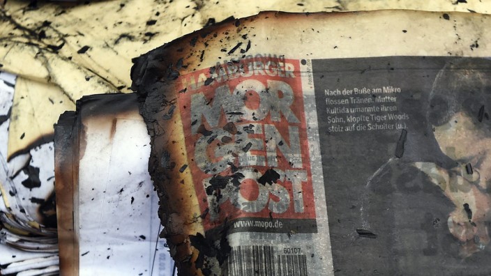 A burned copy of a Hamburger Morgenpost newspaper is pictured among other documents in front of a building of German newspaper Hamburger Morgenpost in Hamburg