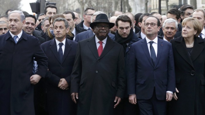 French President Hollande is surrounded by head of states as they attend the solidarity march in the streets of Paris