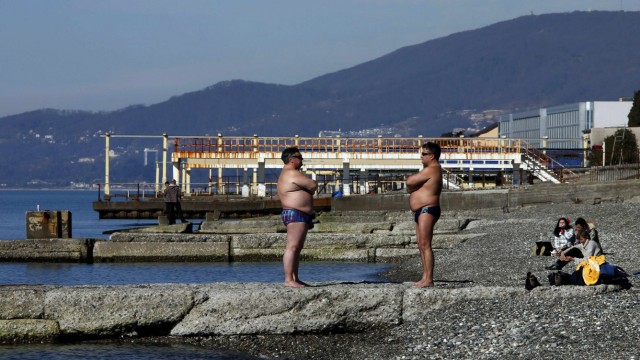 Two men sunbathe on the beach in Adler on a warm and sunny day during the 2014 Sochi Winter Olympics