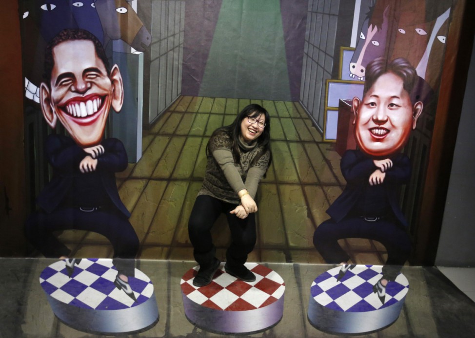 A visitor poses for a photograph in front of a 3D painting in Beijing