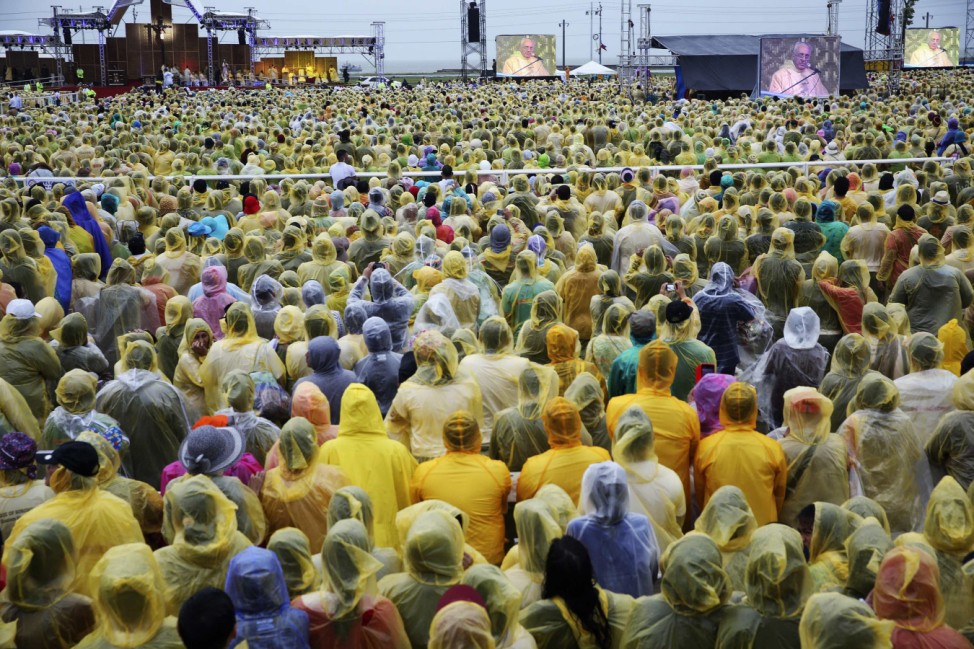 Pope Francis appears on big screens as he leads a mass at Tacloban's airport