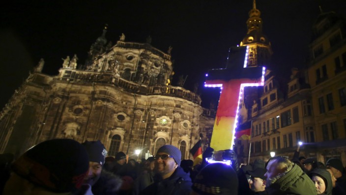 Participants hold a cross painted in the colours of German national flag during a demonstration called by anti-immigration group PEGIDA, a German abbreviation for 'Patriotic Europeans against the Islamization of the West', in Dresden