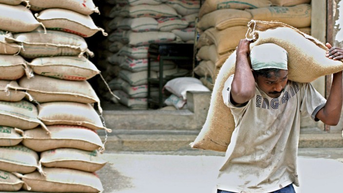 Tagelöhner trägt Reissack auf Landwirtschaftsmarkt