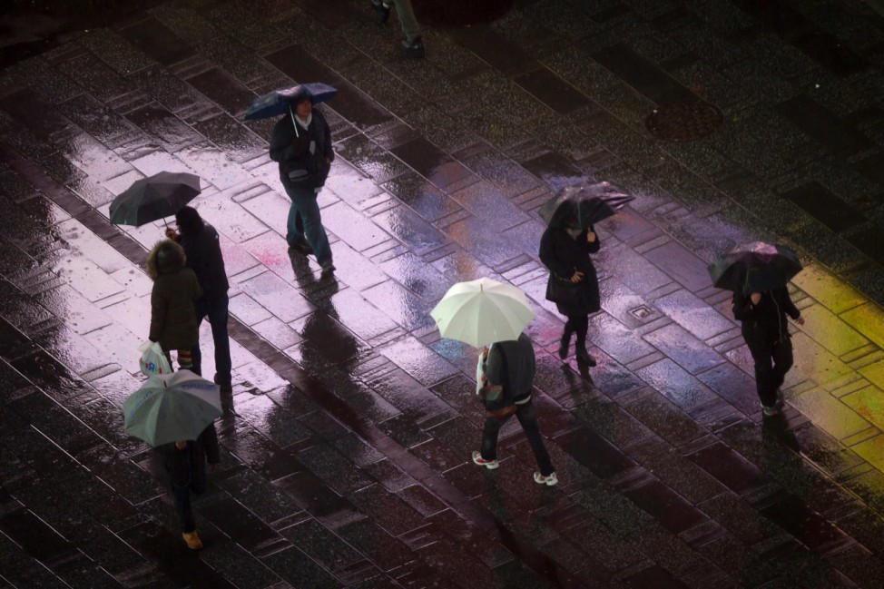 Pedestrians make their way through Times Square in the rain in the Manhattan borough of New York