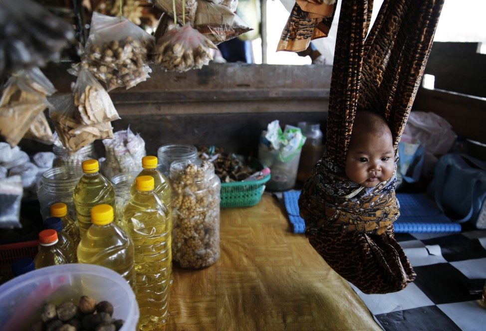 A baby is seen suspended in a cloth hammock at a food stall at Sungai Arut market in Pangkalan Bun
