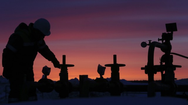 A worker checks the valve of an oil pipe at an oil field owned by Bashneft company near Nikolo-Berezovka