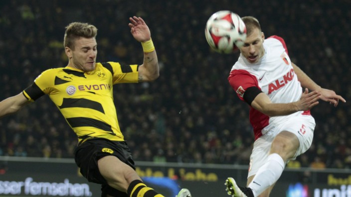 Borussia Dortmund's Immobile challenges FC Augsburg's KLavan during their Bundesliga soccer match in Dortmund